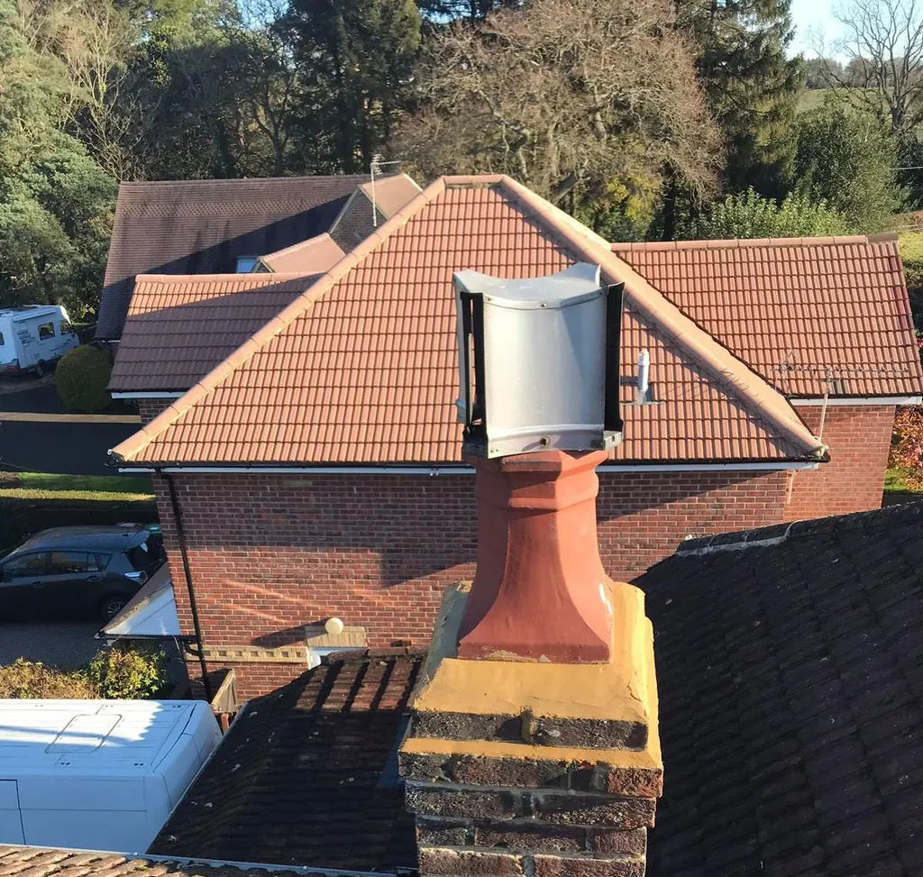 Chimney pot and fresh flaunching above a tiled roof