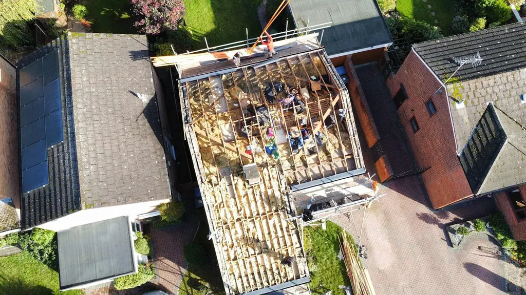 Overhead view of a roof stripped to timber rafters