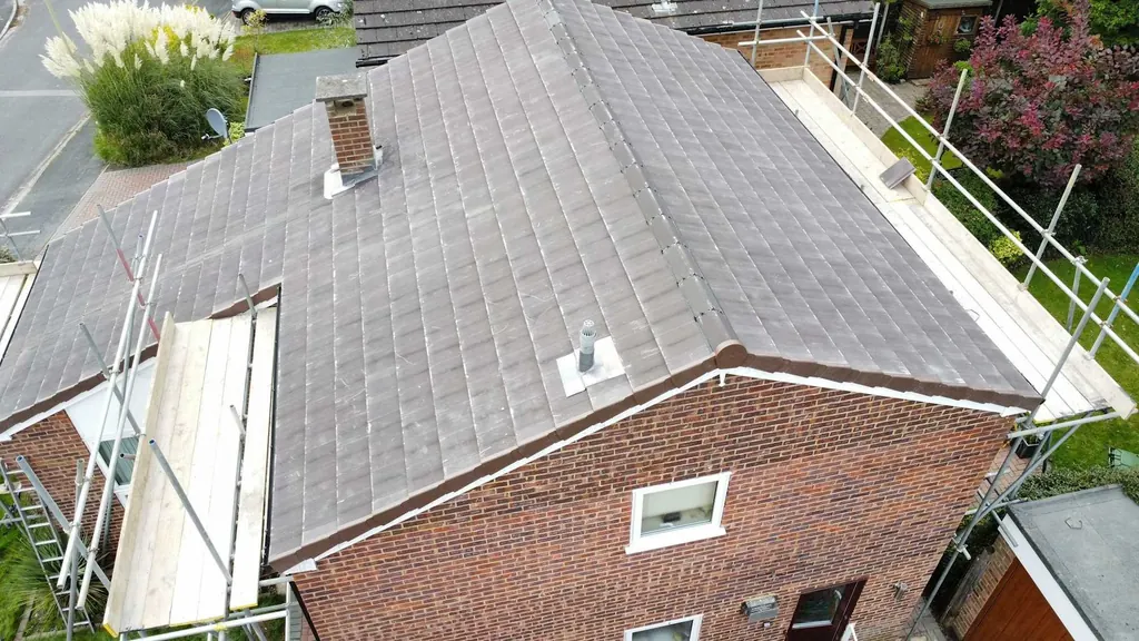 Aerial view of a grey hipped roof and brick gable